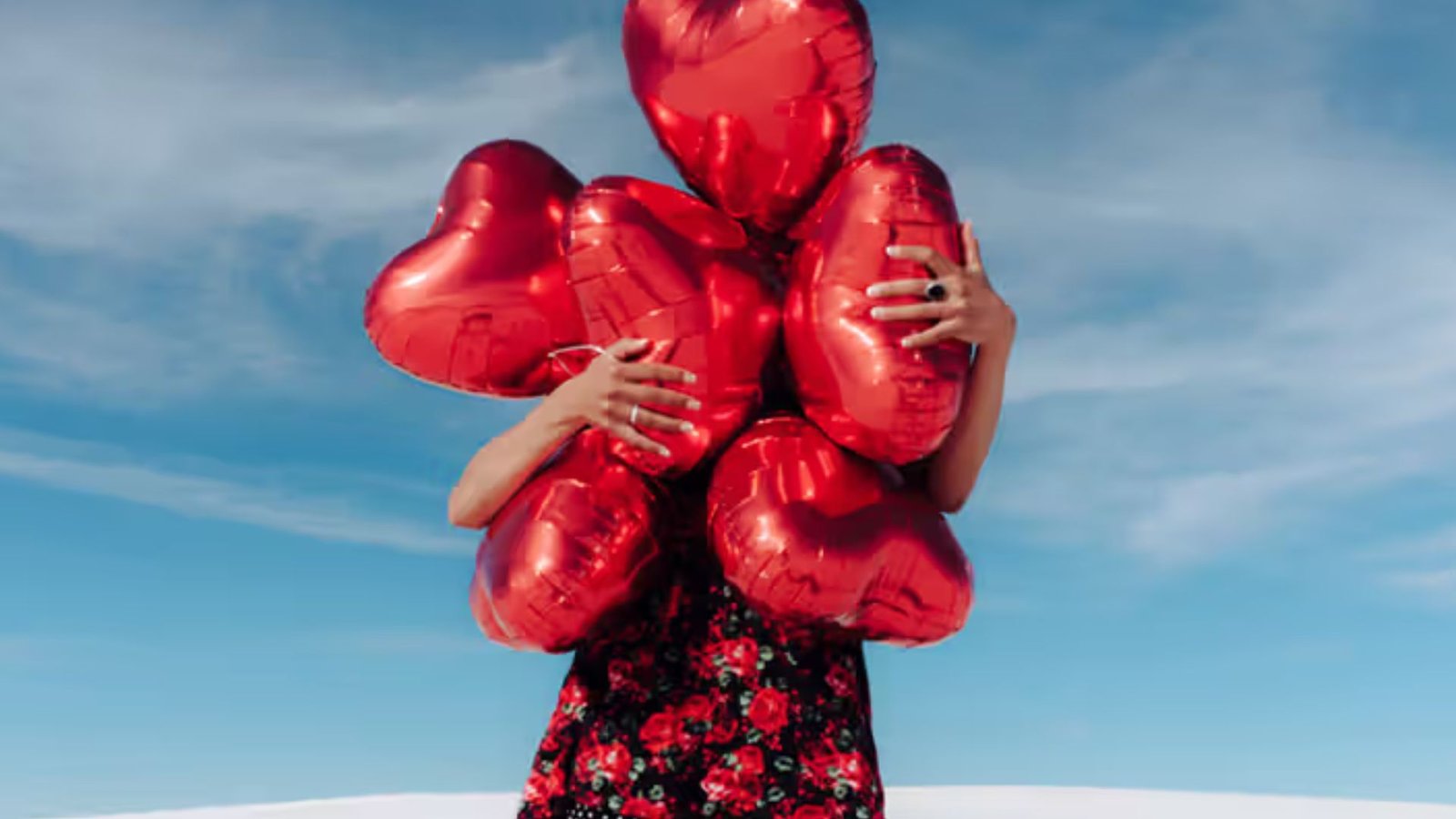 A Woman Holding Red Heart Ballons